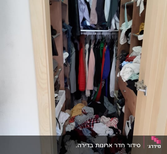 ארון בגדים מבולגן עם בגדים על הרצפה